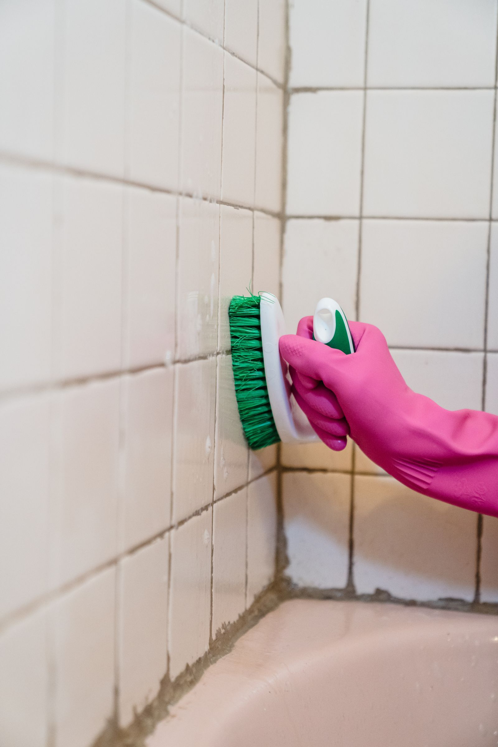 Powered scrub brush cleaning bathroom surfaces